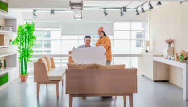 İki profesyonel, parlak ve modern bir çalışma alanında büyük bir planlama tablosunu gözden geçiriyorlar. Sahne, bir başlangıç ortamında takım çalışması, stratejik düşünme ve işbirlikçi proje gelişimini yansıtıyor