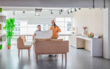 İki profesyonel, parlak ve modern bir çalışma alanında büyük bir planlama tablosunu gözden geçiriyorlar. Sahne, bir başlangıç ortamında takım çalışması, stratejik düşünme ve işbirlikçi proje gelişimini yansıtıyor