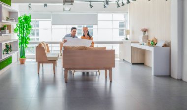 İki profesyonel, parlak ve modern bir çalışma alanında büyük bir planlama tablosunu gözden geçiriyorlar. Sahne, bir başlangıç ortamında takım çalışması, stratejik düşünme ve işbirlikçi proje gelişimini yansıtıyor