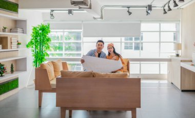 İki profesyonel, parlak ve modern bir çalışma alanında büyük bir planlama tablosunu gözden geçiriyorlar. Sahne, bir başlangıç ortamında takım çalışması, stratejik düşünme ve işbirlikçi proje gelişimini yansıtıyor