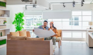 İki profesyonel, parlak ve modern bir çalışma alanında büyük bir planlama tablosunu gözden geçiriyorlar. Sahne, bir başlangıç ortamında takım çalışması, stratejik düşünme ve işbirlikçi proje gelişimini yansıtıyor