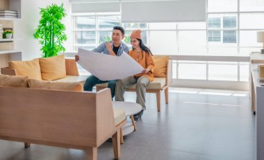 İki profesyonel, parlak ve modern bir çalışma alanında büyük bir planlama tablosunu gözden geçiriyorlar. Sahne, bir başlangıç ortamında takım çalışması, stratejik düşünme ve işbirlikçi proje gelişimini yansıtıyor