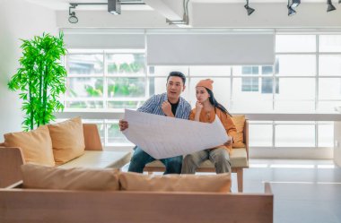 İki profesyonel, parlak ve modern bir çalışma alanında büyük bir planlama tablosunu gözden geçiriyorlar. Sahne, bir başlangıç ortamında takım çalışması, stratejik düşünme ve işbirlikçi proje gelişimini yansıtıyor