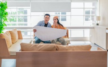 İki profesyonel, parlak ve modern bir çalışma alanında büyük bir planlama tablosunu gözden geçiriyorlar. Sahne, bir başlangıç ortamında takım çalışması, stratejik düşünme ve işbirlikçi proje gelişimini yansıtıyor