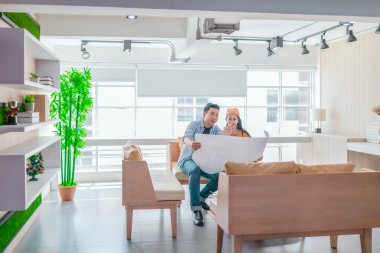 İki profesyonel, parlak ve modern bir çalışma alanında büyük bir planlama tablosunu gözden geçiriyorlar. Sahne, bir başlangıç ortamında takım çalışması, stratejik düşünme ve işbirlikçi proje gelişimini yansıtıyor