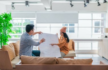 İki profesyonel, parlak ve modern bir çalışma alanında büyük bir planlama tablosunu gözden geçiriyorlar. Sahne, bir başlangıç ortamında takım çalışması, stratejik düşünme ve işbirlikçi proje gelişimini yansıtıyor