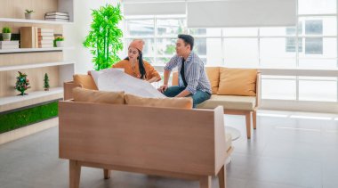 İki profesyonel, parlak ve modern bir çalışma alanında büyük bir planlama tablosunu gözden geçiriyorlar. Sahne, bir başlangıç ortamında takım çalışması, stratejik düşünme ve işbirlikçi proje gelişimini yansıtıyor