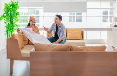 İki profesyonel, parlak ve modern bir çalışma alanında büyük bir planlama tablosunu gözden geçiriyorlar. Sahne, bir başlangıç ortamında takım çalışması, stratejik düşünme ve işbirlikçi proje gelişimini yansıtıyor