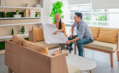 İki profesyonel, parlak ve modern bir çalışma alanında büyük bir planlama tablosunu gözden geçiriyorlar. Sahne, bir başlangıç ortamında takım çalışması, stratejik düşünme ve işbirlikçi proje gelişimini yansıtıyor