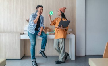 İki iş ortağı modern çalışma alanındaki çeşitli sürdürülebilir ambalaj malzemelerini değerlendiriyor. Yaratıcı işbirliği, ürün tasarımı ve çevreye duyarlı iş uygulamalarının vurgulanması.