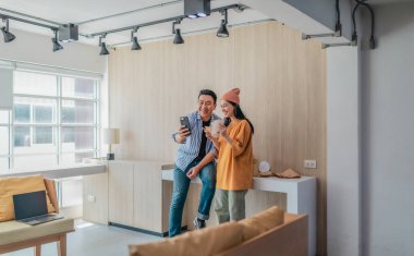 İki iş ortağı modern çalışma alanındaki çeşitli sürdürülebilir ambalaj malzemelerini değerlendiriyor. Yaratıcı işbirliği, ürün tasarımı ve çevreye duyarlı iş uygulamalarının vurgulanması.