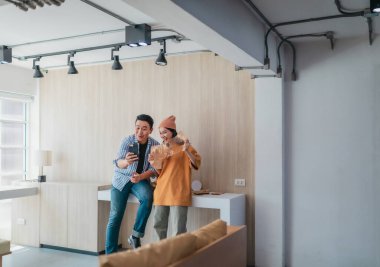 İki iş ortağı modern çalışma alanındaki çeşitli sürdürülebilir ambalaj malzemelerini değerlendiriyor. Yaratıcı işbirliği, ürün tasarımı ve çevreye duyarlı iş uygulamalarının vurgulanması.