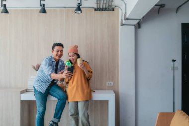 İki iş ortağı modern çalışma alanındaki çeşitli sürdürülebilir ambalaj malzemelerini değerlendiriyor. Yaratıcı işbirliği, ürün tasarımı ve çevreye duyarlı iş uygulamalarının vurgulanması.