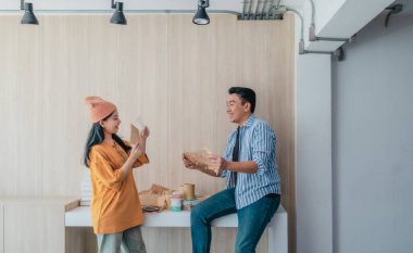 İki iş ortağı modern çalışma alanındaki çeşitli sürdürülebilir ambalaj malzemelerini değerlendiriyor. Yaratıcı işbirliği, ürün tasarımı ve çevreye duyarlı iş uygulamalarının vurgulanması.