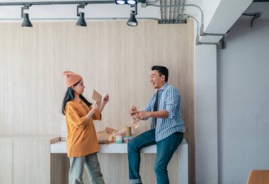 İki iş ortağı modern çalışma alanındaki çeşitli sürdürülebilir ambalaj malzemelerini değerlendiriyor. Yaratıcı işbirliği, ürün tasarımı ve çevreye duyarlı iş uygulamalarının vurgulanması.