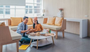 İki girişimci, modern bir çalışma alanında sürdürülebilir ambalaj örneklerini gözden geçiriyorlar. Çevre dostu materyaller ve ürün prototipleriyle çevrelenmiş olarak ürün geliştirme ve markalaşma fikirlerini tartışıyorlar.