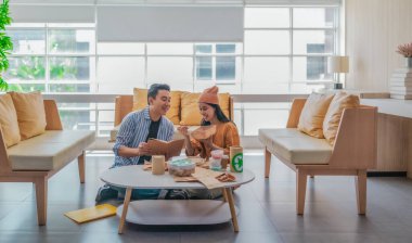 İki girişimci, modern bir çalışma alanında sürdürülebilir ambalaj örneklerini gözden geçiriyorlar. Çevre dostu materyaller ve ürün prototipleriyle çevrelenmiş olarak ürün geliştirme ve markalaşma fikirlerini tartışıyorlar.