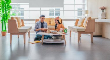 İki girişimci, modern bir çalışma alanında sürdürülebilir ambalaj örneklerini gözden geçiriyorlar. Çevre dostu materyaller ve ürün prototipleriyle çevrelenmiş olarak ürün geliştirme ve markalaşma fikirlerini tartışıyorlar.