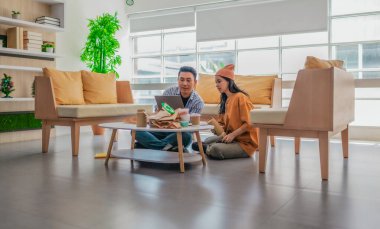 İki girişimci, modern bir çalışma alanında sürdürülebilir ambalaj örneklerini gözden geçiriyorlar. Çevre dostu materyaller ve ürün prototipleriyle çevrelenmiş olarak ürün geliştirme ve markalaşma fikirlerini tartışıyorlar.