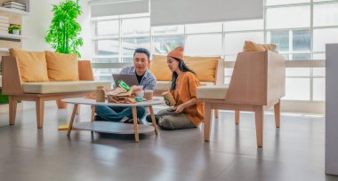 İki girişimci, modern bir çalışma alanında sürdürülebilir ambalaj örneklerini gözden geçiriyorlar. Çevre dostu materyaller ve ürün prototipleriyle çevrelenmiş olarak ürün geliştirme ve markalaşma fikirlerini tartışıyorlar.