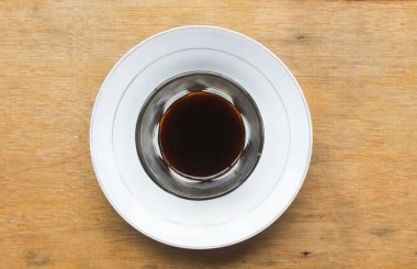 Şeffaf bir bardak ve sarnıçta sade kahve servis edilir. Yukarıdaki fotoğrafta.