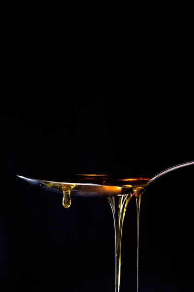 honey drizzling onto a spoon 