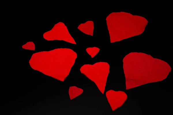 broken red valentine hearts on a black background, for february valentine\'s day celebration