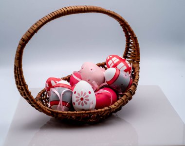 wicker basket with colored easter eggs, on a white background in the period of easter 2023