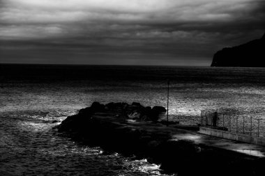 İtalyan Liguria 'sında, Spotorno Denizi' ndeki bir rıhtımın siyah beyaz fotoğrafı.