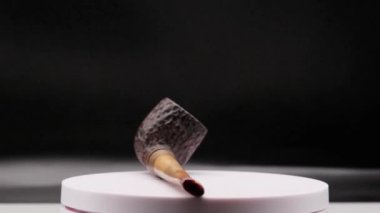 Tütün içmek için eski bir ahşap pipoyu 4k video, beyaz arka planda kendi kendine dönüyor.
