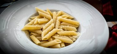 İtalyan restoranında soslu ve peynirli bir tabak rigatoni makarna.