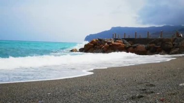 Deniz dalgaları, Ağustos ayının sıcak bir yaz sabahı Ligurian 'ın batısındaki Spotorno sahiline çarpar.