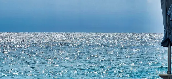 Tatillerde deniz kıyısındaki tatil beldesindeki kumsalda güneşlik ve şemsiyeler