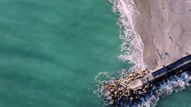 4k deniz dalgalarının insansız hava aracı tarafından çekilmiş görüntüleri, sıcak bir kış gününde Ligurian sahilinde Spotorno 'ya çarpıyor.
