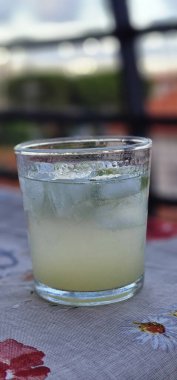 a gin and tonic in a glass, an alcoholic summer cocktail for evenings by the sea