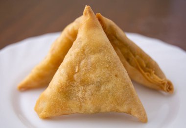 Delicious traditional indian samosas on white plate