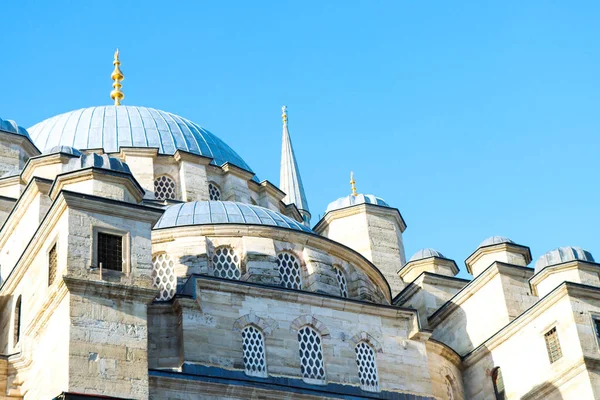 Mavi gökyüzünün önündeki cami kubbesinin tepesinde 