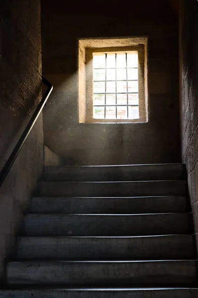 Tek pencereli karanlık oda. Güneşin ışıldayan ışınlarıyla havadaki tozu gösteriyor. 