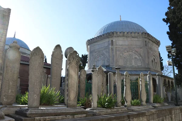 Güneşli bir günde cami kubbesinin önüne eski mezar taşları konur. 