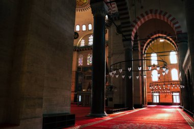  interior of mosque with red carpets and light coming through its windows