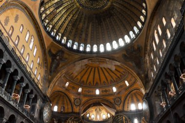 roof of Hagia Sophia with light peeking through windows and ancient paintings on the walls