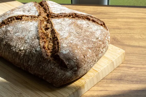 Güneş ışığında ahşap masanın üzerinde ekmek.