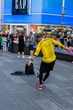 Sarı gömlekli bir adam New York 'ta futbol oynuyor.