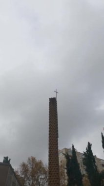 Üzerinde haç olan tuğla bir yapıya sahip bir kiliseye doğru gidiyor.