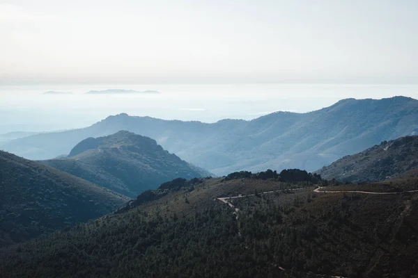 Las Villuercas, Cceres 'te sisli bir sabahta ağaçlı dağların katmanları