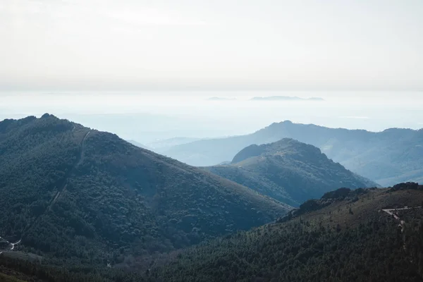 Las Villuercas, Cceres 'te sisli bir sabahta ağaçlı dağların katmanları