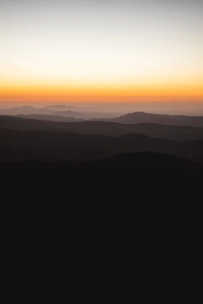 Vertical view of beautiful layers of mountains with golden light after sunset in Las Villuercas, Caceres, Extremadura, Spain
