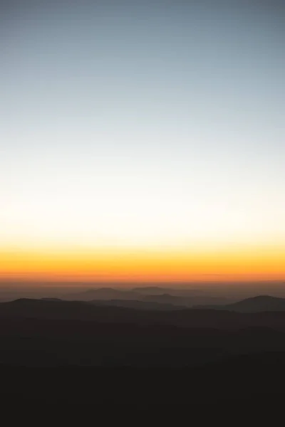 Vertical view of beautiful layers of mountains with golden light after sunset in Las Villuercas, Caceres, Extremadura, Spain