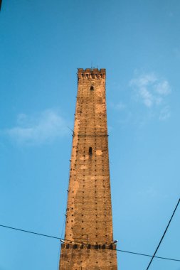 The iconic Tower of Asinelli in Bologna stands tall against a stunning blue sky with clouds. A perfect representation of Italian architecture and culture.