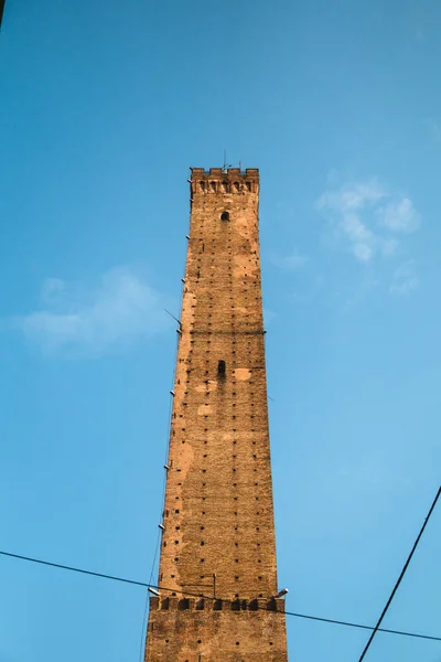 The iconic Tower of Asinelli in Bologna stands tall against a stunning blue sky with clouds. A perfect representation of Italian architecture and culture.